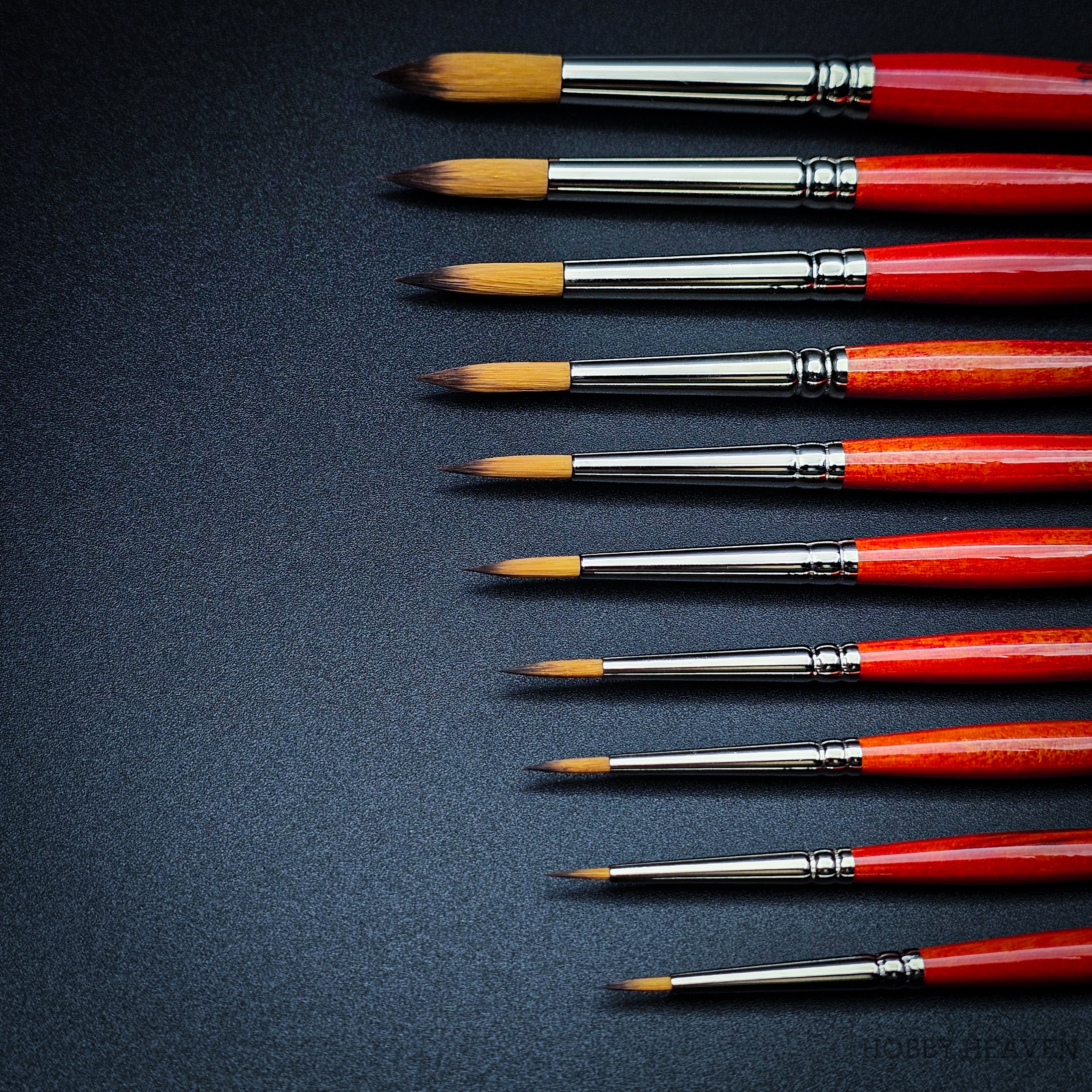 Close-up of Raphael Series 8394 Kaerell round brushes with red handles for fine detail and watercolour painting