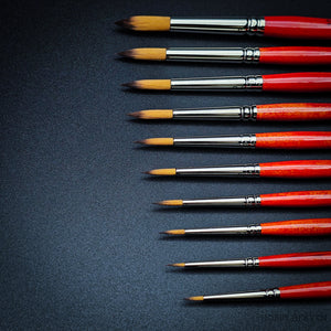 Close-up of Raphael Series 8394 Kaerell round brushes with red handles for fine detail and watercolour painting