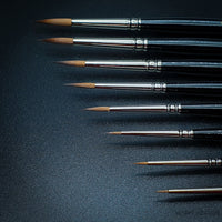 Raphael Kolinsky Sable Series 8404 brush set, showcasing various sizes of premium watercolor brushes in horizontal view on black background
