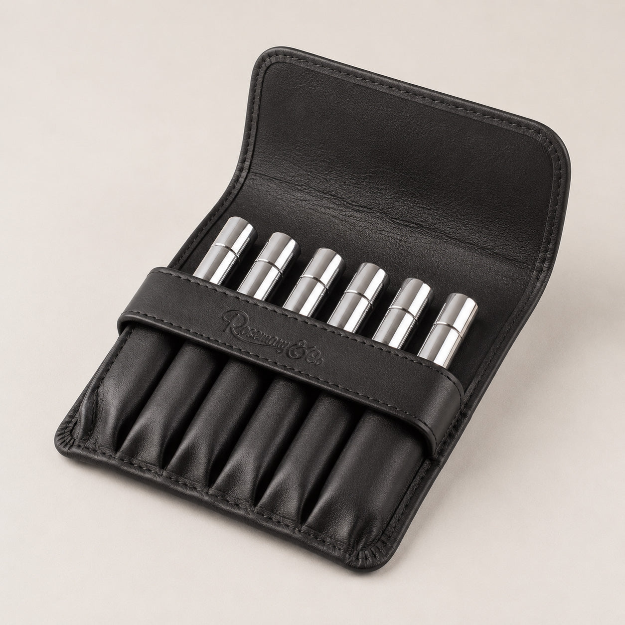 Open Rosemary & Co black leather 6 pocket brush wallet showing short travel brushes stored in individual sleeves