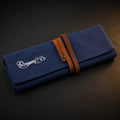 Rosemary & Co large navy fabric brush wrap shown closed with leather strap and embroidered logo