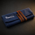 Rosemary & Co small navy fabric brush wrap shown closed with leather strap and embroidered logo