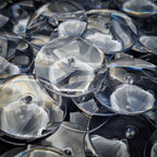 Close-up of 32mm PS plastic clear base showing scratch-resistant surface and exceptional clarity compared to standard acrylic