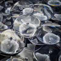Close-up of 32mm PS plastic clear base showing scratch-resistant surface and exceptional clarity compared to standard acrylic

