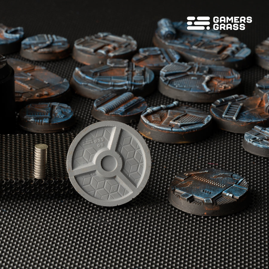 Bare underside of a 32mm base: a single central magnet recess between three ribs, with small magnets stacked beside it