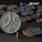 Underside of a 50mm base showing three magnet slots set around a central hub, with a stack of magnets on the mat