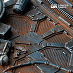 Close-up of the 100mm base: hexagonal floor panels, mesh insets, rusted pipework and a canister stencilled DANGER