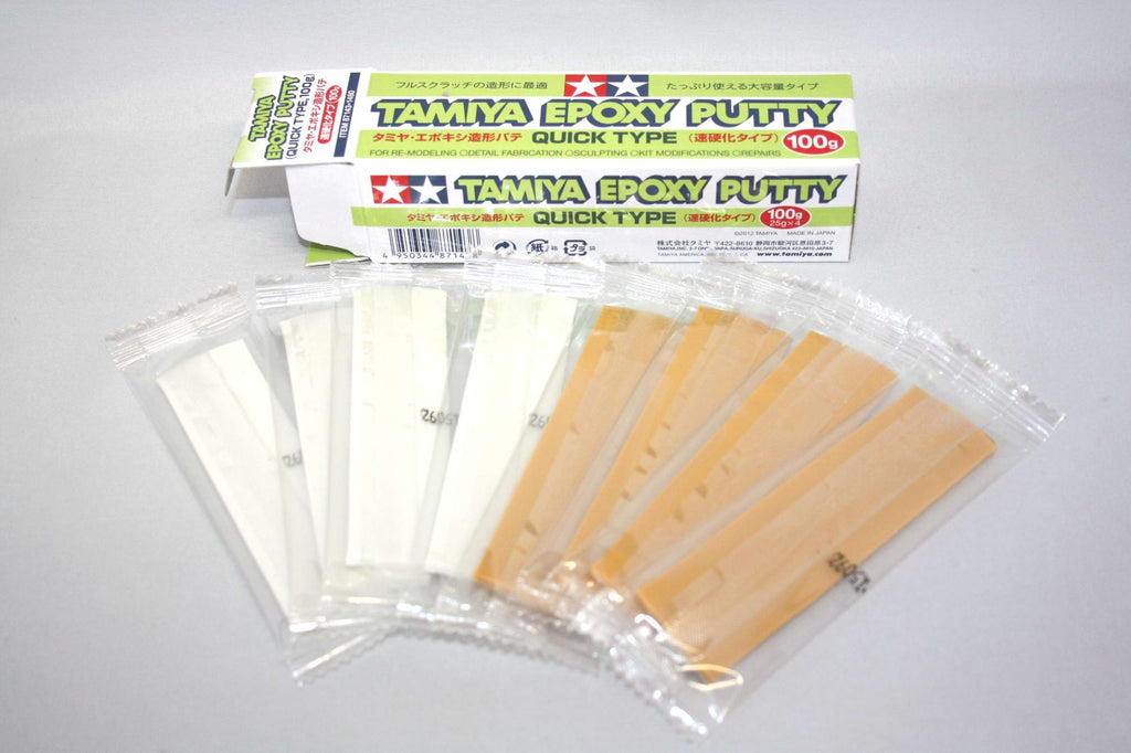 Tamiya Epoxy Putty Quick Type 100g box open, four white putty strips and four beige hardener strips