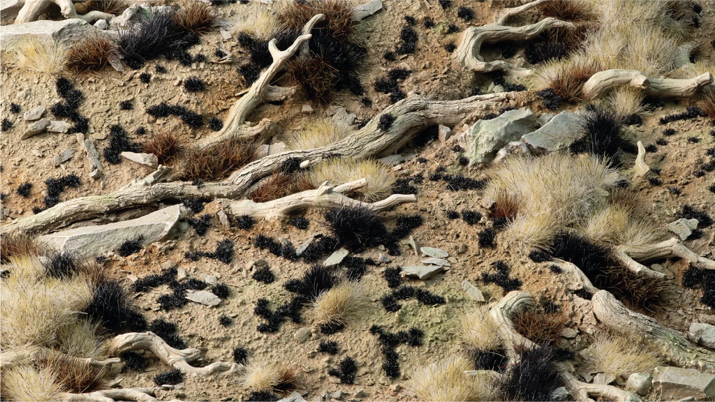 Gamers Grass Tiny Black 1mm tufts scattered on arid wasteland diorama with dried tufts bleached wood and rocks