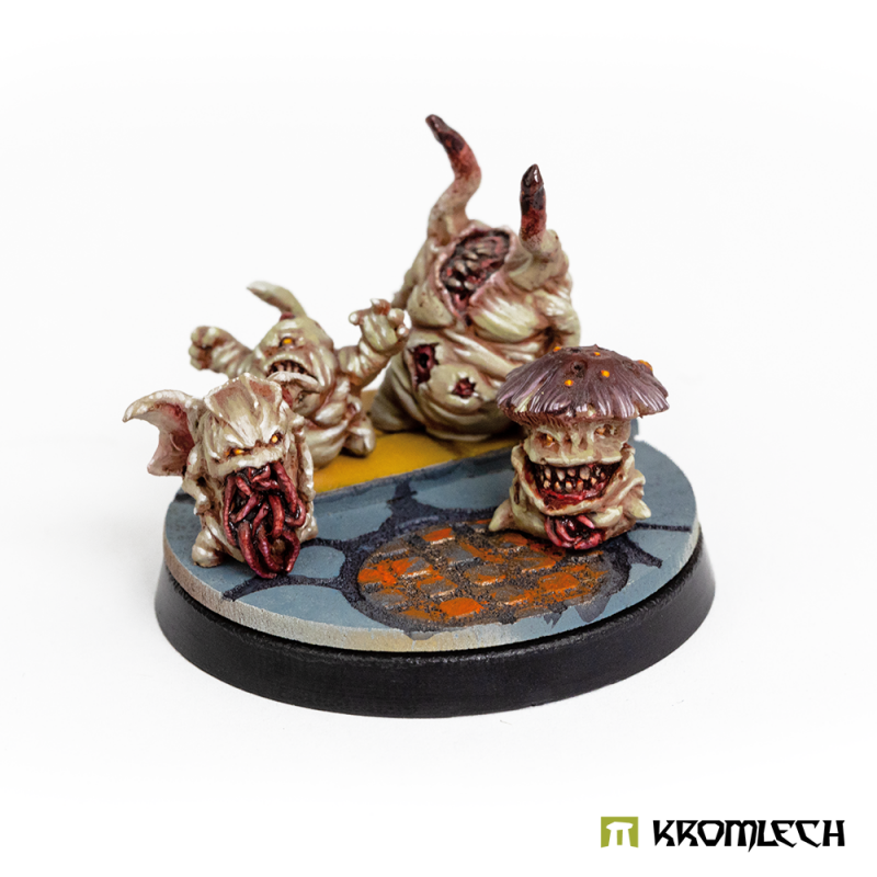 Painted pale toothy creatures on a Town Streets round base topper, shown for scale (miniatures not included)