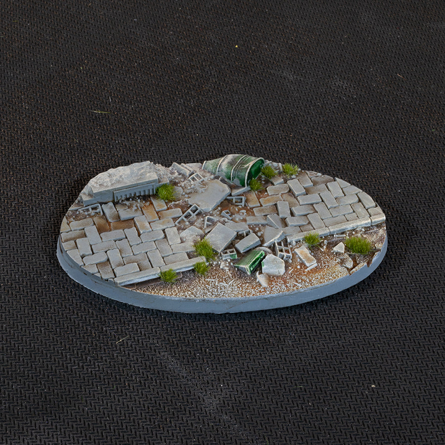 Collapsed paving with a crushed fuel drum and scattered debris, 90 mm Urban Warfare oval base