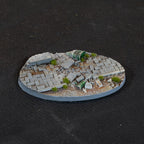 Collapsed paving with a crushed fuel drum and scattered debris, 90 mm Urban Warfare oval base