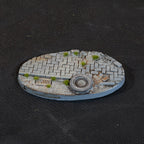 Brick paving, a drain grate and a discarded tyre in gravel, on a 90 mm Urban Warfare oval base