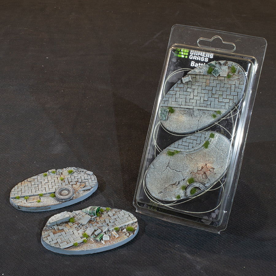 Blister and both 90 mm Urban Warfare oval bases, paving broken up by rubble and grass tufts