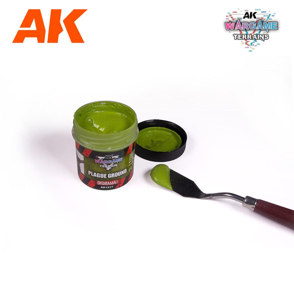 AK1217 Plague Ground jar open beside its lid, filled with thick yellow-green paste, with a loaded palette knife alongside