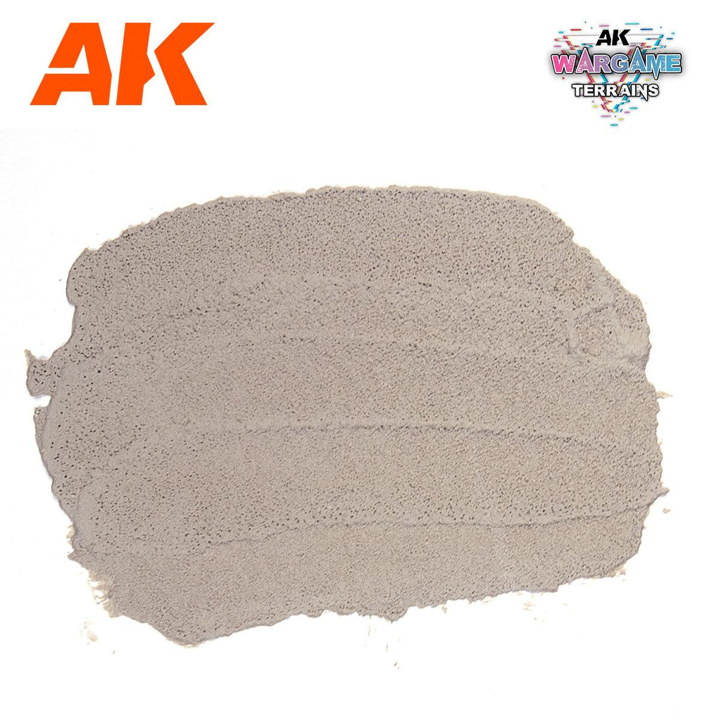 A spread swatch of AK1229 Concrete on white, showing the finely pitted cement-like surface it dries to