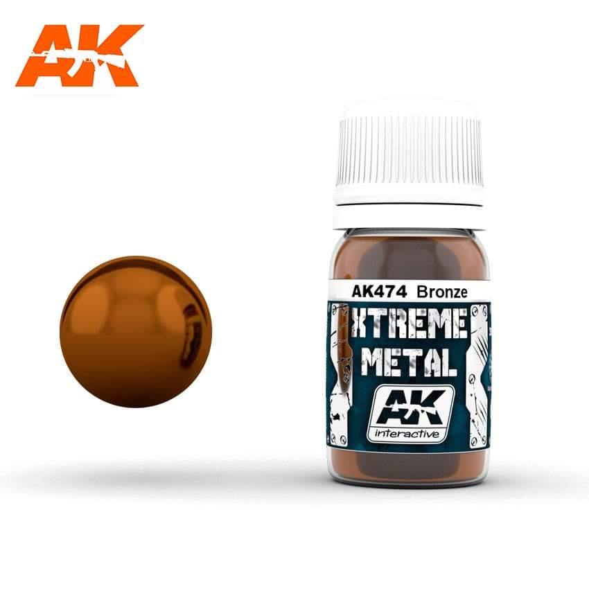 AK474 Xtreme Metal Bronze: 30ml bottle with a ribbed white cap, beside a mirror-bright warm coppery brown sphere.
