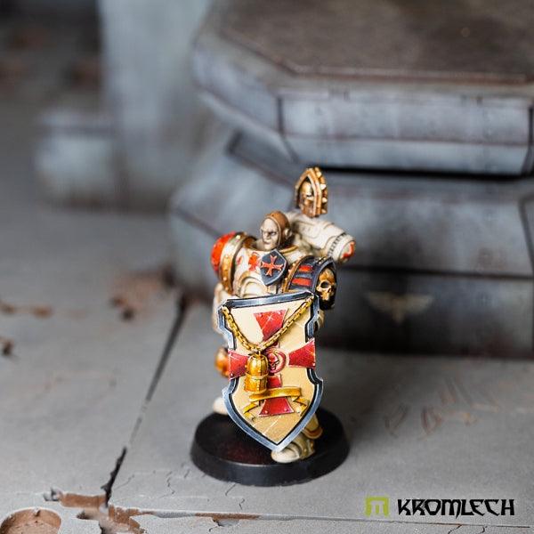 The same shield seen from the side on a finished crusader miniature, the left arm tucked in close behind the shield face