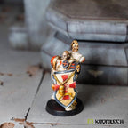 The same shield seen from the side on a finished crusader miniature, the left arm tucked in close behind the shield face